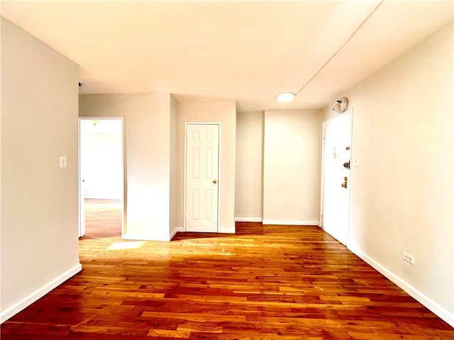 empty room with baseboards and wood finished floors