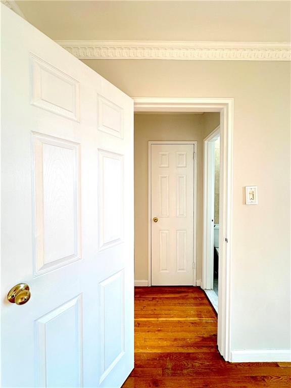 corridor with crown molding and dark hardwood / wood-style floors