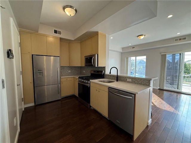 kitchen with stainless steel appliances, kitchen peninsula, sink, and plenty of natural light