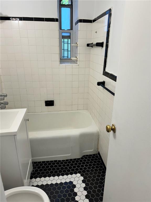 full bath featuring bathtub / shower combination, toilet, and vanity