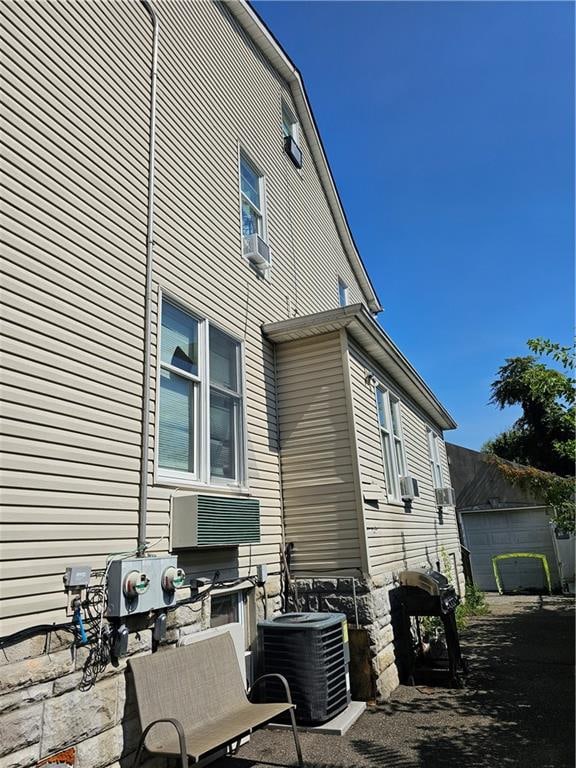 view of home's exterior with central air condition unit, an outdoor structure, and a garage