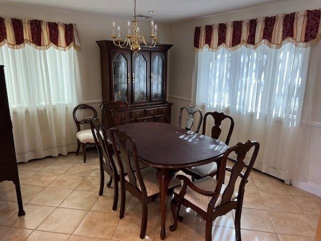 dining space with a wealth of natural light, a chandelier, and light tile patterned floors