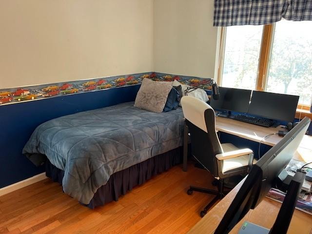 bedroom with baseboards and wood finished floors