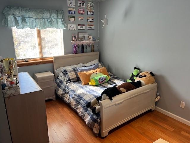 bedroom featuring baseboards and wood finished floors