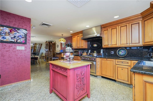 kitchen featuring decorative backsplash, wooden counters, wall chimney range hood, high end stainless steel range, and a kitchen island