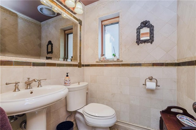 bathroom with sink, toilet, tile walls, and ornamental molding