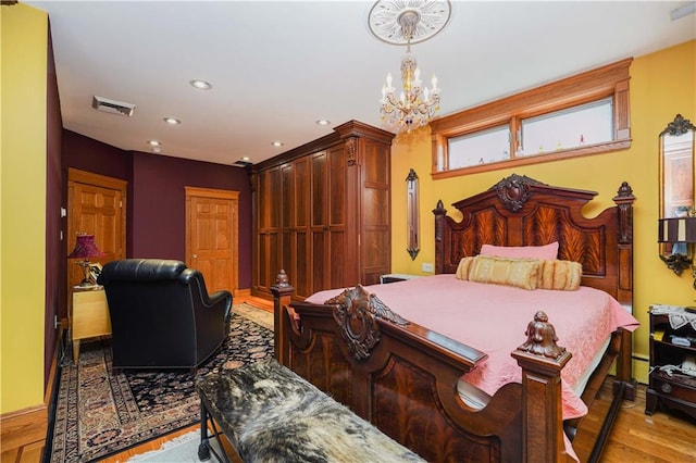 bedroom with light hardwood / wood-style flooring and a notable chandelier