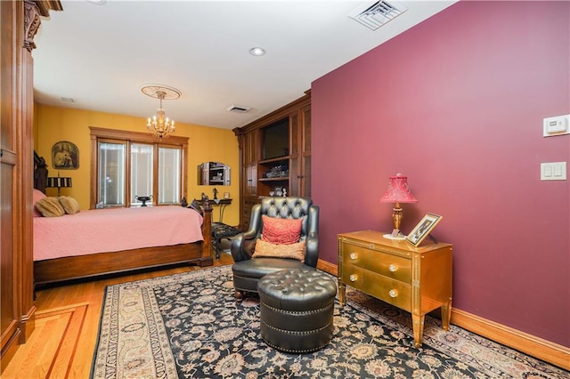 bedroom featuring a chandelier and hardwood / wood-style flooring