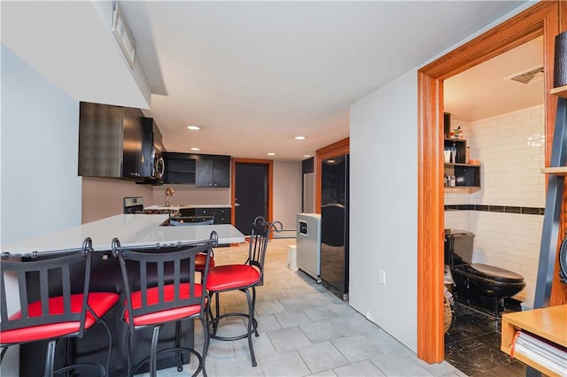 kitchen featuring kitchen peninsula, electric range, and a breakfast bar