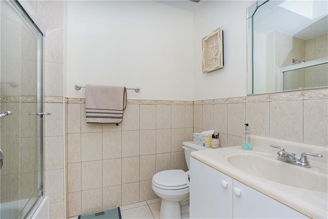 full bathroom featuring vanity, tile walls, enclosed tub / shower combo, tile patterned flooring, and toilet