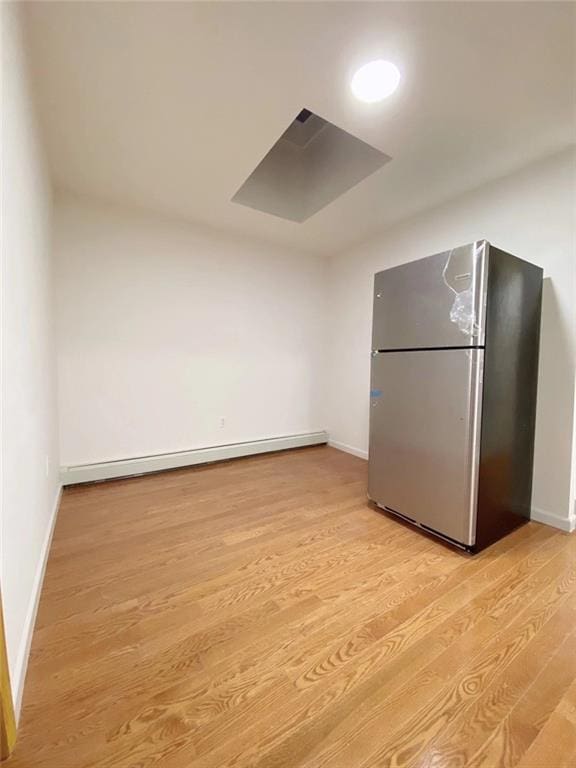 kitchen featuring stainless steel fridge, light hardwood / wood-style floors, and a baseboard heating unit