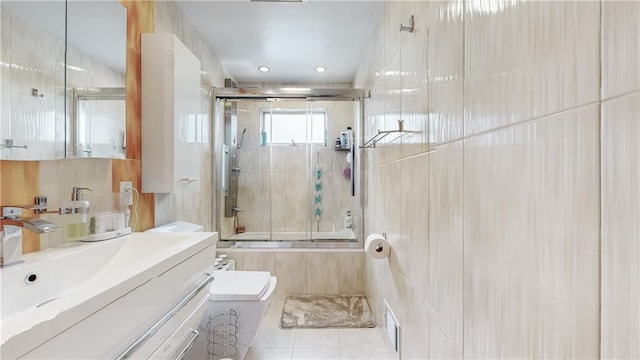 full bath with toilet, enclosed tub / shower combo, tile patterned floors, vanity, and tile walls