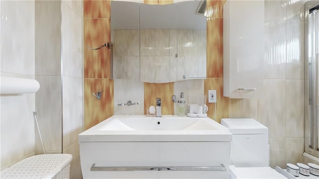 bathroom with tile walls and toilet