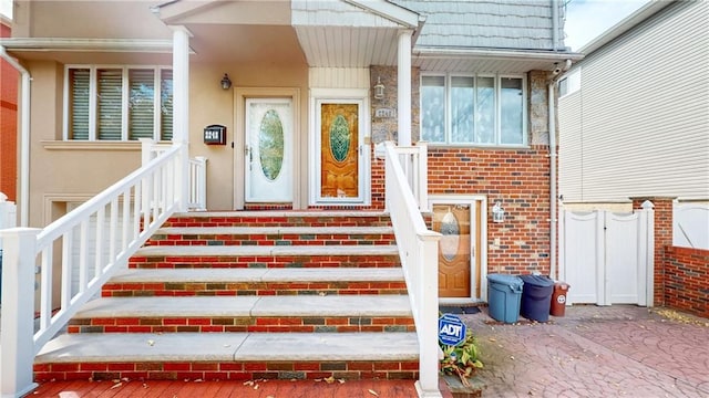 entrance to property with brick siding and stucco siding