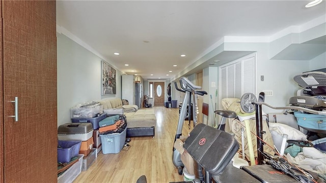 workout area with recessed lighting and light wood finished floors