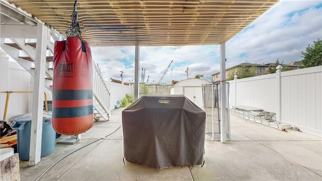 view of patio featuring an outbuilding, a storage shed, area for grilling, and a fenced backyard