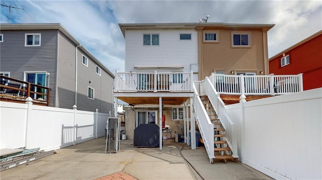 rear view of property featuring stairway, fence, a deck, and a patio