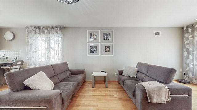 living room with light wood-style floors and visible vents