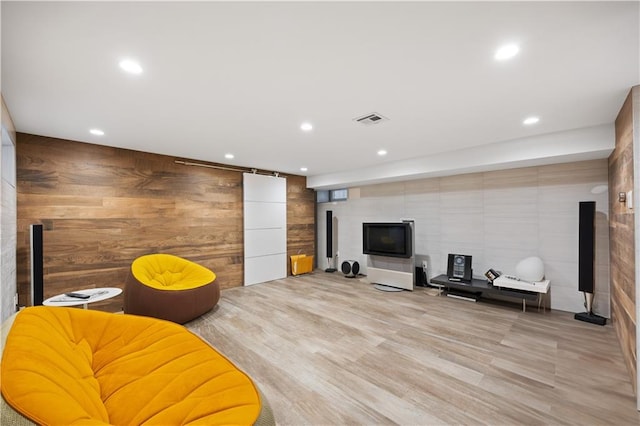 living room featuring light hardwood / wood-style flooring and wood walls