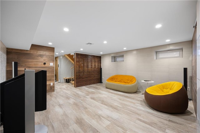 sitting room featuring wooden walls and light wood-type flooring