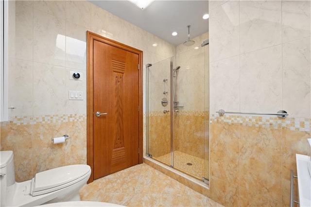 bathroom featuring tile walls, a shower with shower door, and toilet