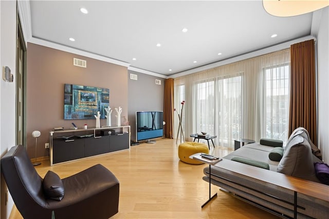 living room featuring light wood-type flooring and crown molding