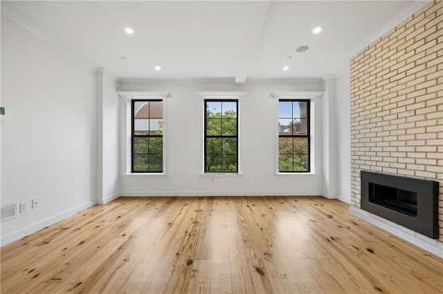 unfurnished living room featuring a brick fireplace, baseboards, beamed ceiling, ornamental molding, and wood-type flooring