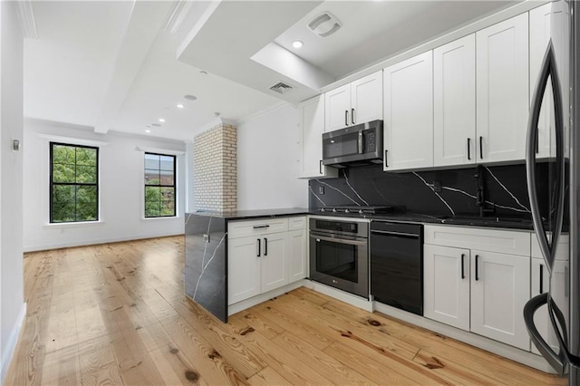 kitchen featuring visible vents, dark countertops, black appliances, and a peninsula