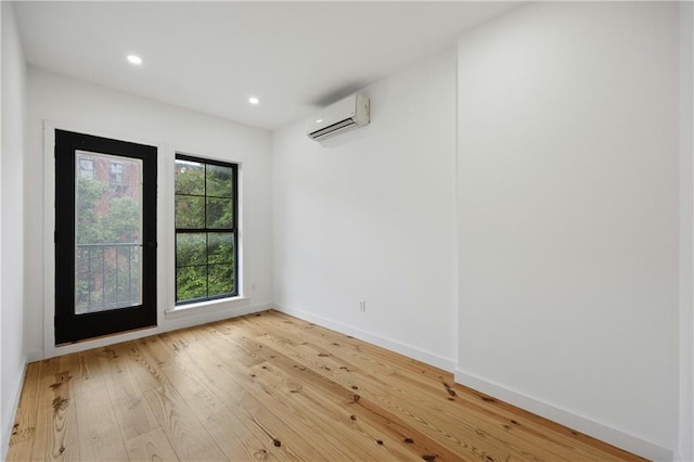 unfurnished room with hardwood / wood-style flooring and an AC wall unit