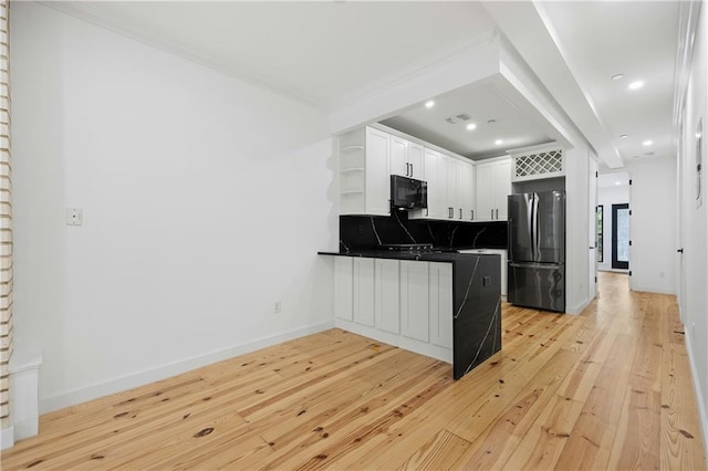 kitchen featuring light hardwood / wood-style flooring, stainless steel fridge, decorative backsplash, crown molding, and white cabinetry