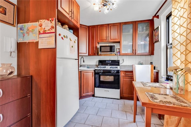 kitchen featuring white appliances, light tile patterned floors, backsplash, and sink