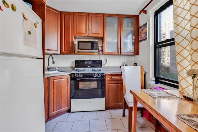 kitchen featuring sink, white appliances, backsplash, and light tile patterned floors