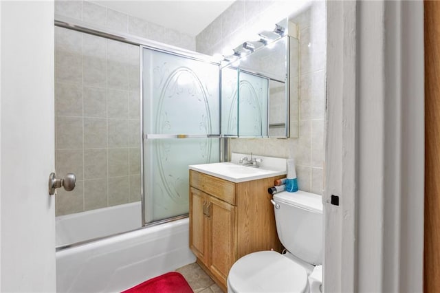 full bathroom featuring vanity, tile patterned floors, toilet, and enclosed tub / shower combo