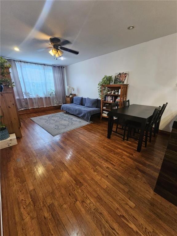 living room with ceiling fan and dark wood-type flooring