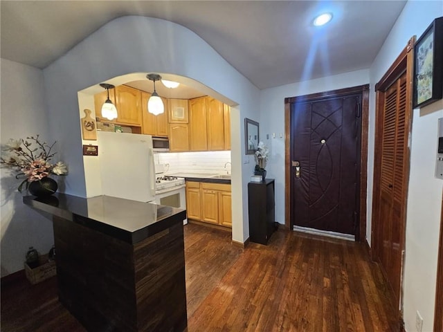 kitchen featuring pendant lighting, white appliances, tasteful backsplash, light brown cabinetry, and dark hardwood / wood-style flooring