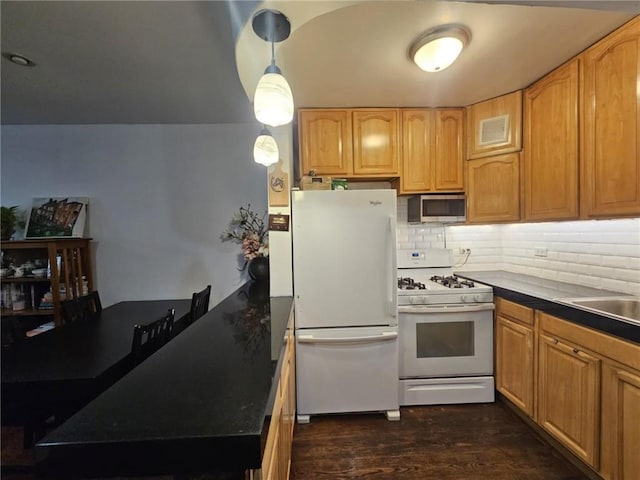 kitchen featuring decorative light fixtures, backsplash, dark wood-type flooring, and white appliances