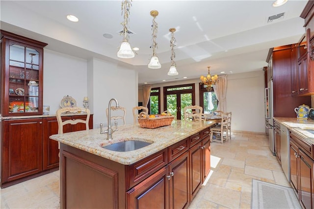 kitchen featuring a kitchen island with sink, sink, pendant lighting, and french doors