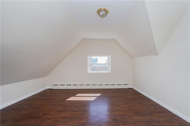 additional living space with a baseboard radiator, lofted ceiling, and dark hardwood / wood-style floors