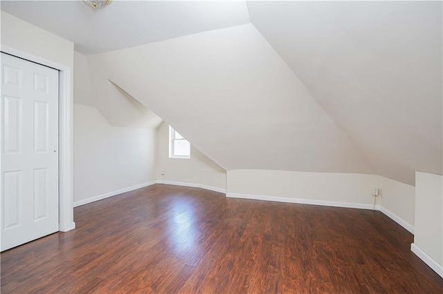 additional living space featuring lofted ceiling and dark wood-type flooring