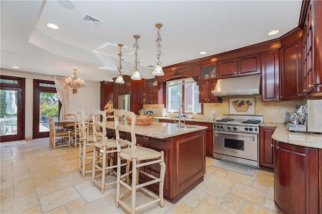 kitchen with a kitchen bar, an inviting chandelier, hanging light fixtures, a kitchen island, and high end stainless steel range oven