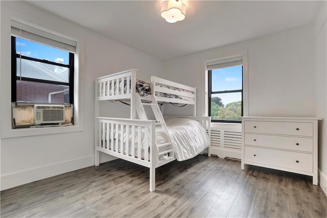 unfurnished bedroom featuring cooling unit, wood finished floors, and baseboards