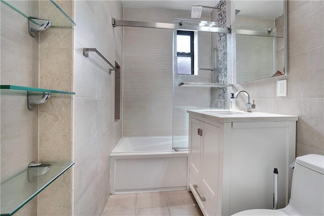 bathroom featuring tile patterned flooring, tile walls, toilet, and vanity