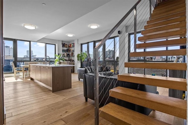 interior space featuring light hardwood / wood-style flooring, a center island with sink, and sink