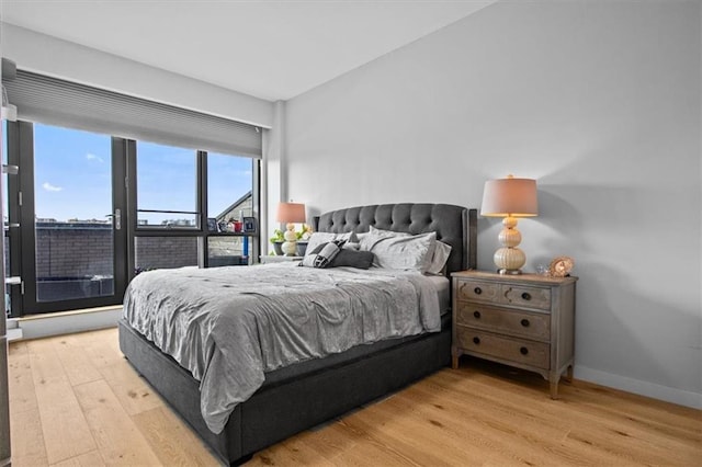 bedroom with light wood-style flooring and baseboards