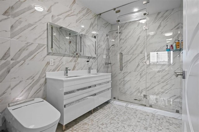 bathroom with a marble finish shower, tile walls, and vanity