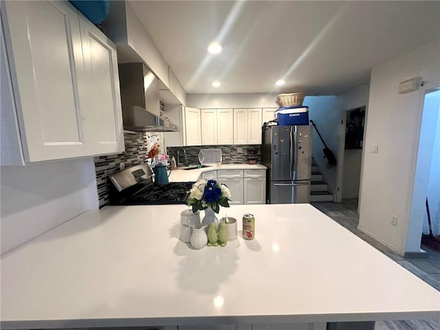15 Bay 20th St, Brooklyn, NY 11214 - kitchen with stainless steel appliances, wall chimney range hood, tasteful backsplash, a peninsula, and light countertops