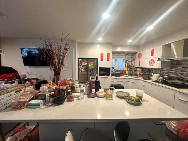 15 Bay 20th St, Brooklyn, NY 11214 - kitchen featuring wall chimney range hood, white cabinetry, cooktop, and light countertops