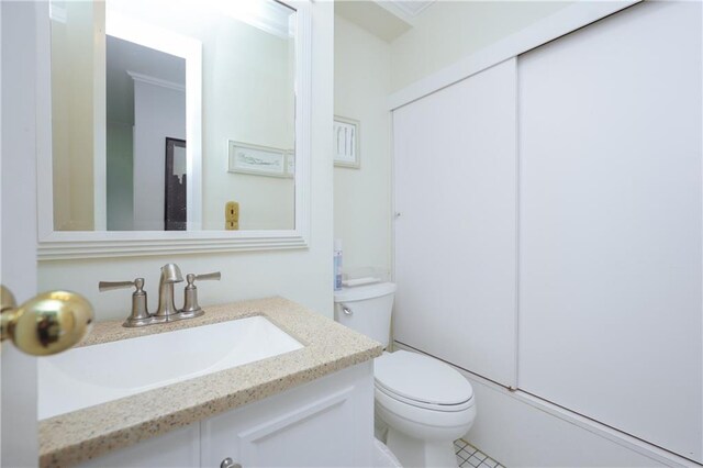 bathroom featuring toilet, ornamental molding, vanity, and tile patterned floors