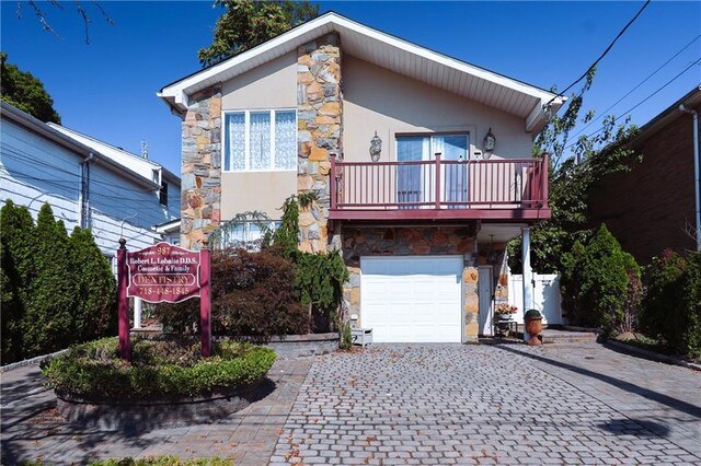 view of front of home with a balcony and a garage