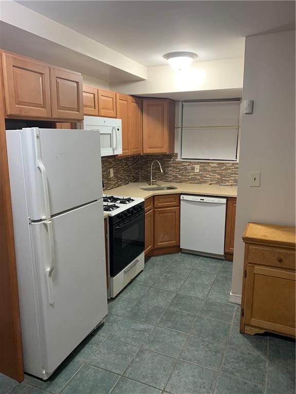 kitchen with white appliances, light countertops, backsplash, and a sink